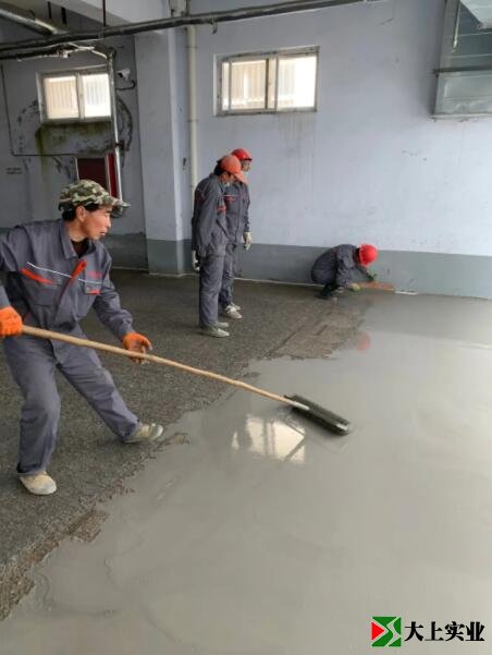 工人正在摊铺地下车库地坪材料