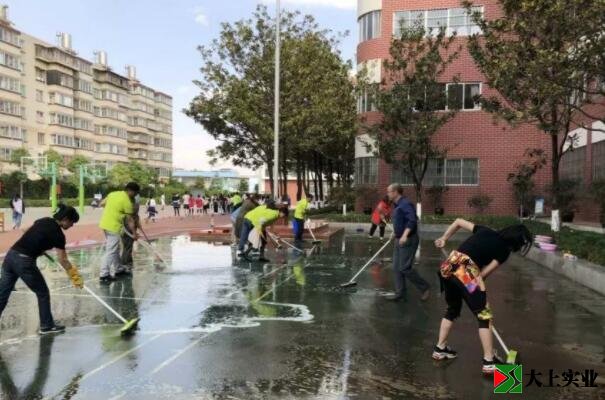 党总支书记王炳林带领大家清洗塑胶运动场的场景