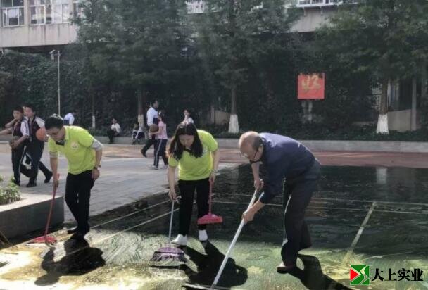王炳林带领大家清洗塑胶球场的场景